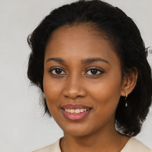 Joyful black young-adult female with long  brown hair and brown eyes