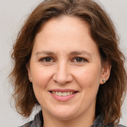 Joyful white adult female with medium  brown hair and grey eyes