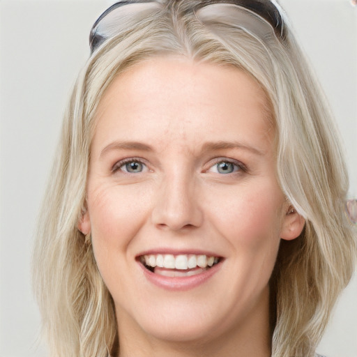 Joyful white young-adult female with long  blond hair and blue eyes