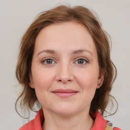 Joyful white young-adult female with medium  brown hair and blue eyes