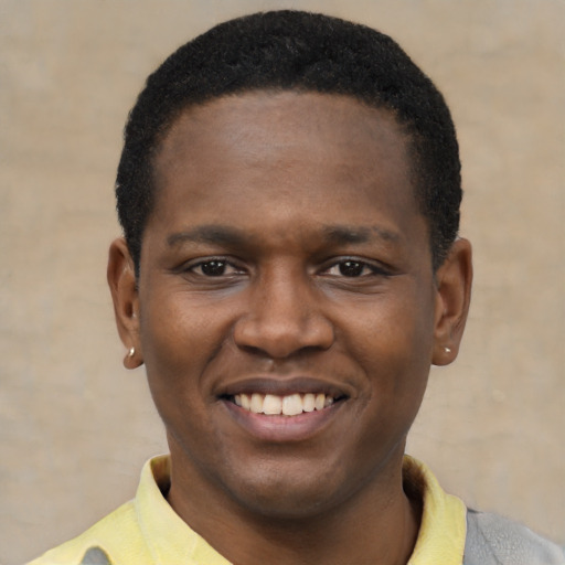 Joyful black young-adult male with short  black hair and brown eyes