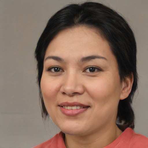 Joyful asian adult female with medium  brown hair and brown eyes