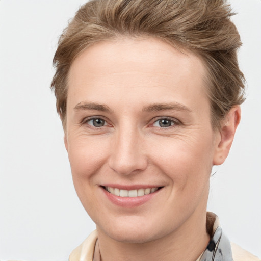 Joyful white young-adult female with short  brown hair and grey eyes