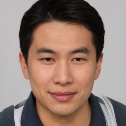 Joyful asian young-adult male with short  brown hair and brown eyes