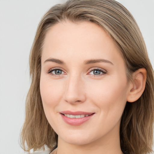 Joyful white young-adult female with long  brown hair and blue eyes