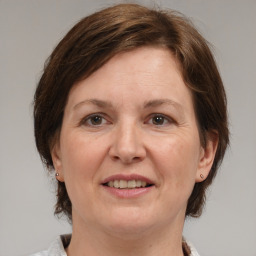 Joyful white adult female with medium  brown hair and grey eyes