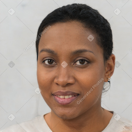 Joyful black young-adult female with short  black hair and brown eyes