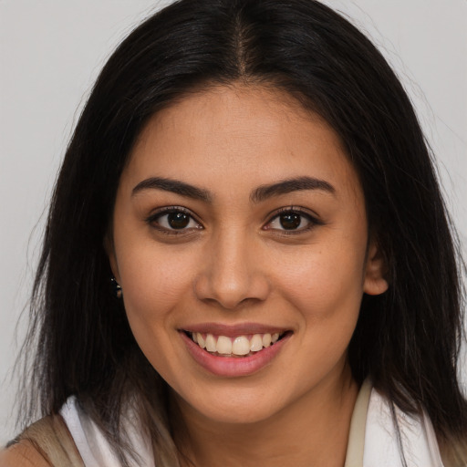 Joyful latino young-adult female with long  brown hair and brown eyes