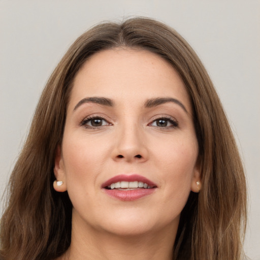 Joyful white young-adult female with long  brown hair and brown eyes