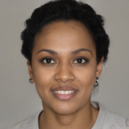 Joyful black young-adult female with short  black hair and brown eyes