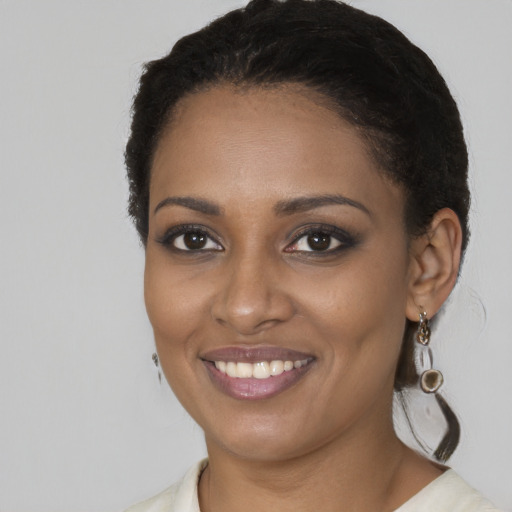 Joyful black young-adult female with long  brown hair and brown eyes