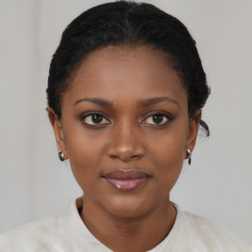 Joyful black young-adult female with short  black hair and brown eyes