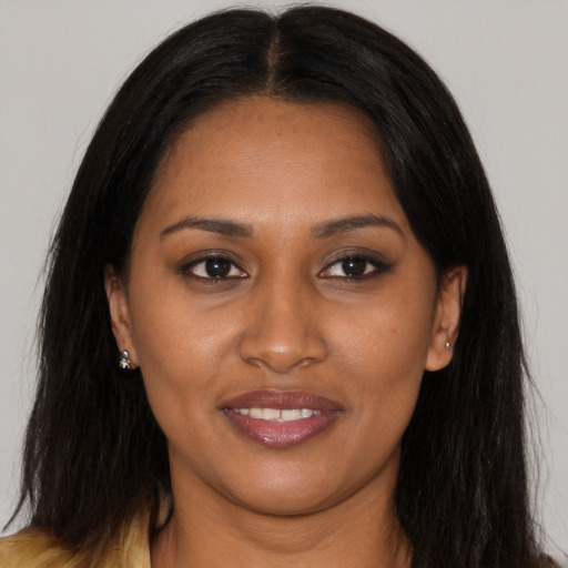 Joyful black young-adult female with long  brown hair and brown eyes