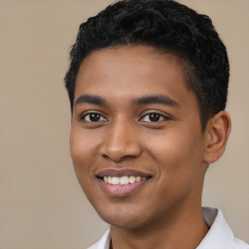 Joyful black young-adult male with short  black hair and brown eyes