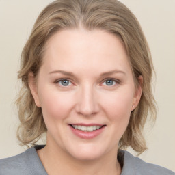 Joyful white young-adult female with medium  brown hair and blue eyes