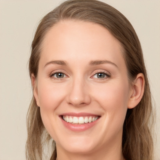 Joyful white young-adult female with long  brown hair and green eyes