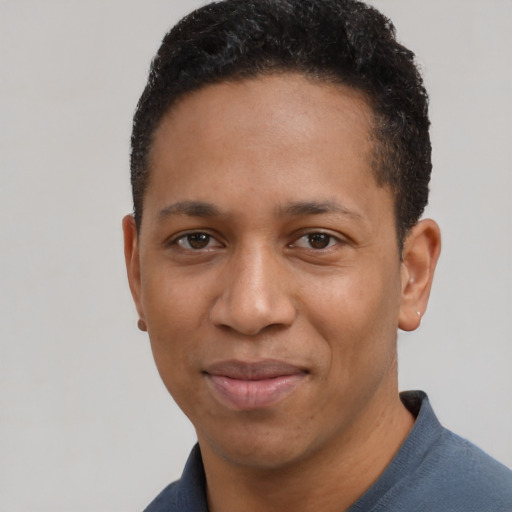Joyful black young-adult male with short  black hair and brown eyes