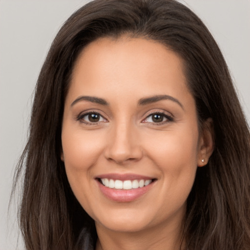 Joyful white young-adult female with long  brown hair and brown eyes