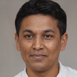 Joyful latino adult male with short  black hair and brown eyes