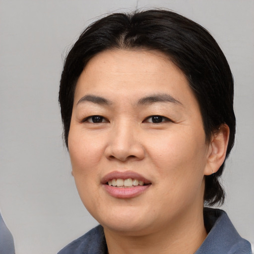 Joyful asian young-adult female with medium  brown hair and brown eyes