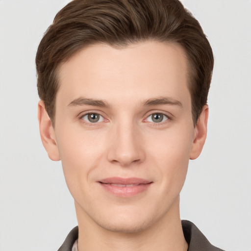 Joyful white young-adult male with short  brown hair and grey eyes