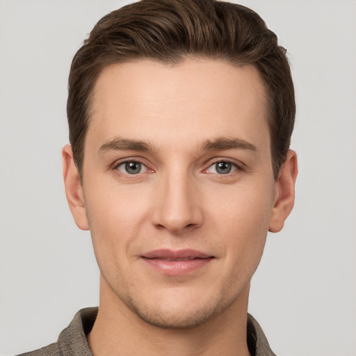 Joyful white young-adult male with short  brown hair and grey eyes