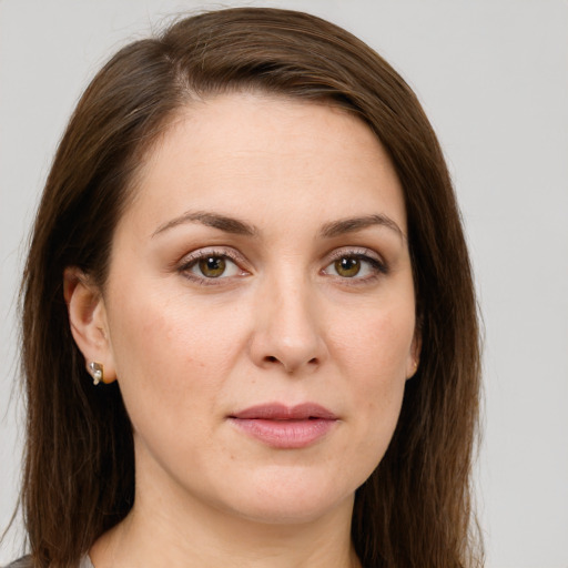 Joyful white young-adult female with long  brown hair and green eyes