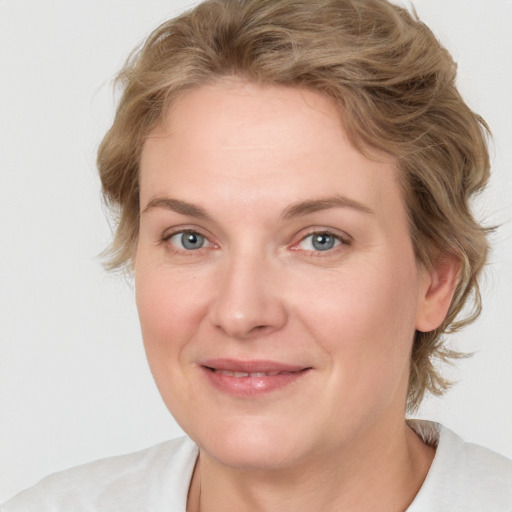 Joyful white adult female with medium  brown hair and blue eyes