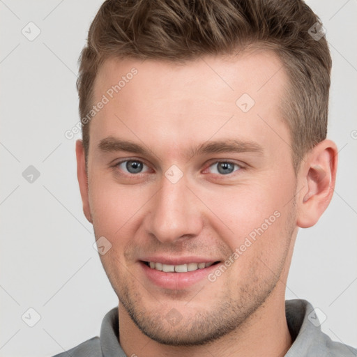 Joyful white young-adult male with short  brown hair and grey eyes