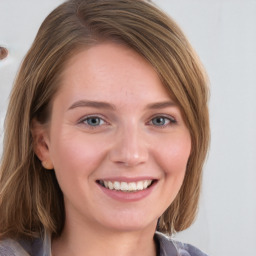 Joyful white young-adult female with long  brown hair and blue eyes