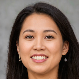 Joyful latino young-adult female with long  brown hair and brown eyes