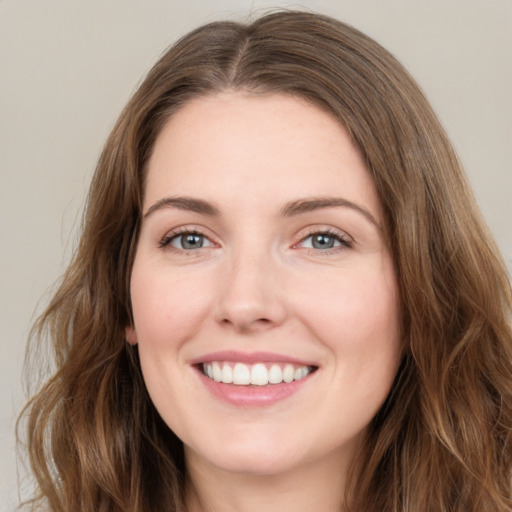 Joyful white young-adult female with long  brown hair and green eyes