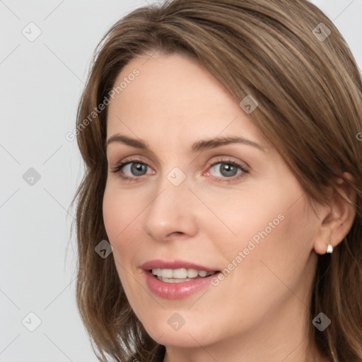 Joyful white young-adult female with long  brown hair and grey eyes