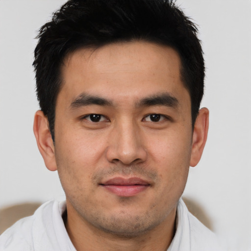 Joyful asian young-adult male with short  brown hair and brown eyes
