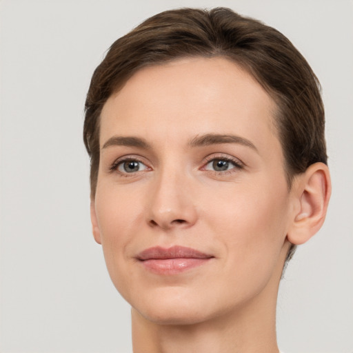 Joyful white young-adult female with short  brown hair and grey eyes