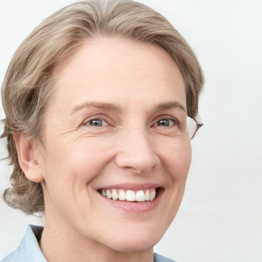 Joyful white adult female with medium  brown hair and blue eyes