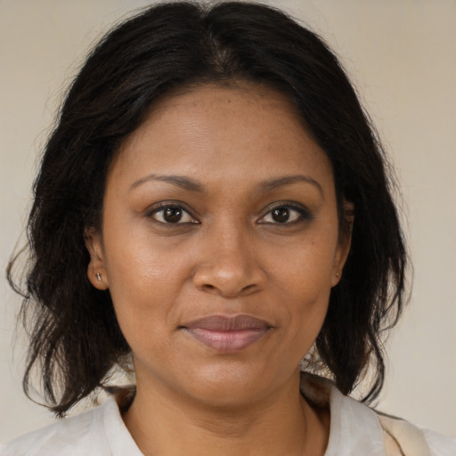 Joyful black adult female with medium  brown hair and brown eyes