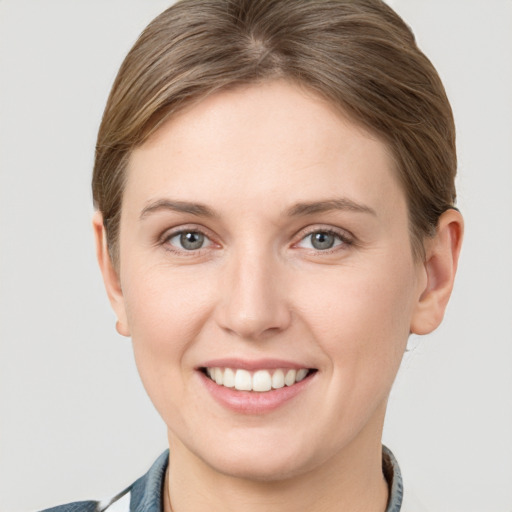 Joyful white young-adult female with short  brown hair and grey eyes