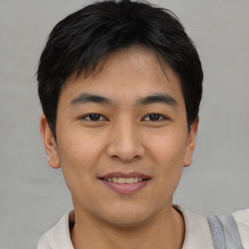 Joyful asian young-adult male with short  brown hair and brown eyes