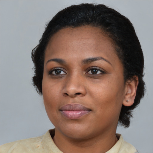 Joyful black young-adult female with short  black hair and brown eyes