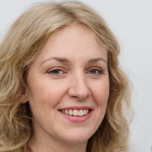 Joyful white adult female with long  brown hair and blue eyes