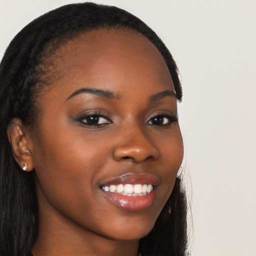 Joyful black young-adult female with long  brown hair and brown eyes