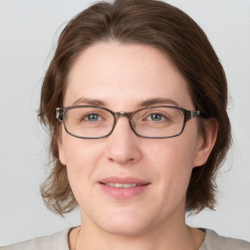 Joyful white adult female with medium  brown hair and green eyes