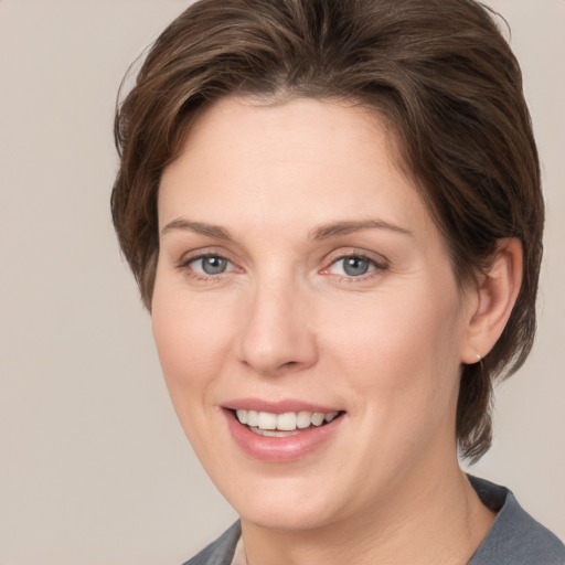 Joyful white young-adult female with medium  brown hair and grey eyes