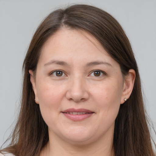Joyful white adult female with long  brown hair and grey eyes