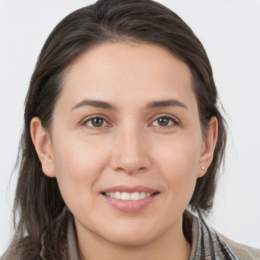 Joyful white young-adult female with long  brown hair and brown eyes