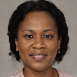 Joyful black adult female with medium  brown hair and brown eyes