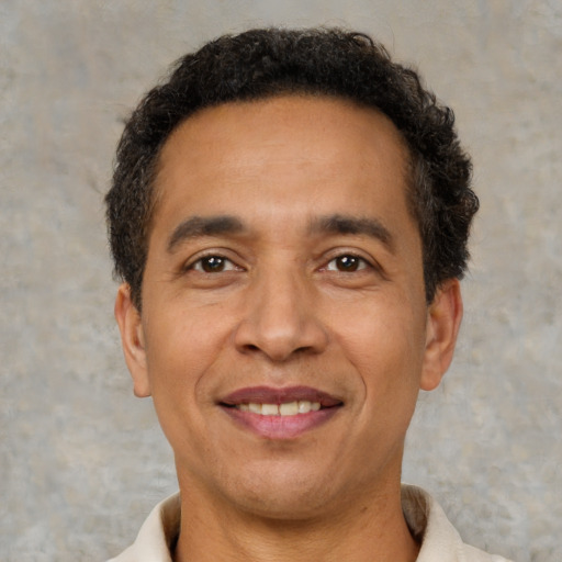 Joyful latino adult male with short  brown hair and brown eyes