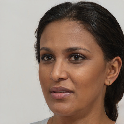 Joyful black adult female with medium  brown hair and brown eyes