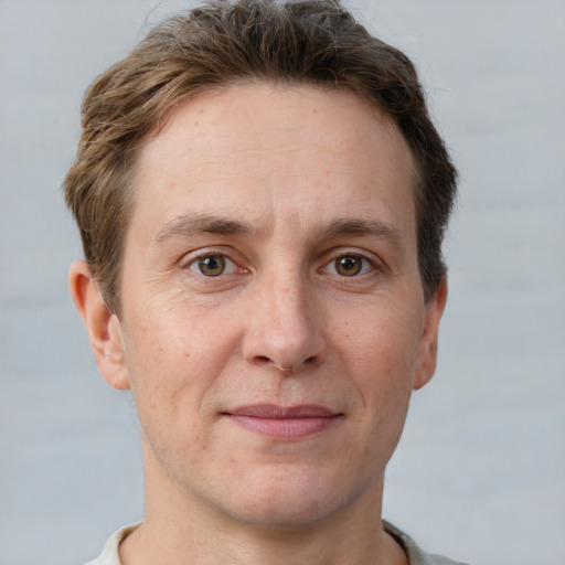 Joyful white adult male with short  brown hair and grey eyes